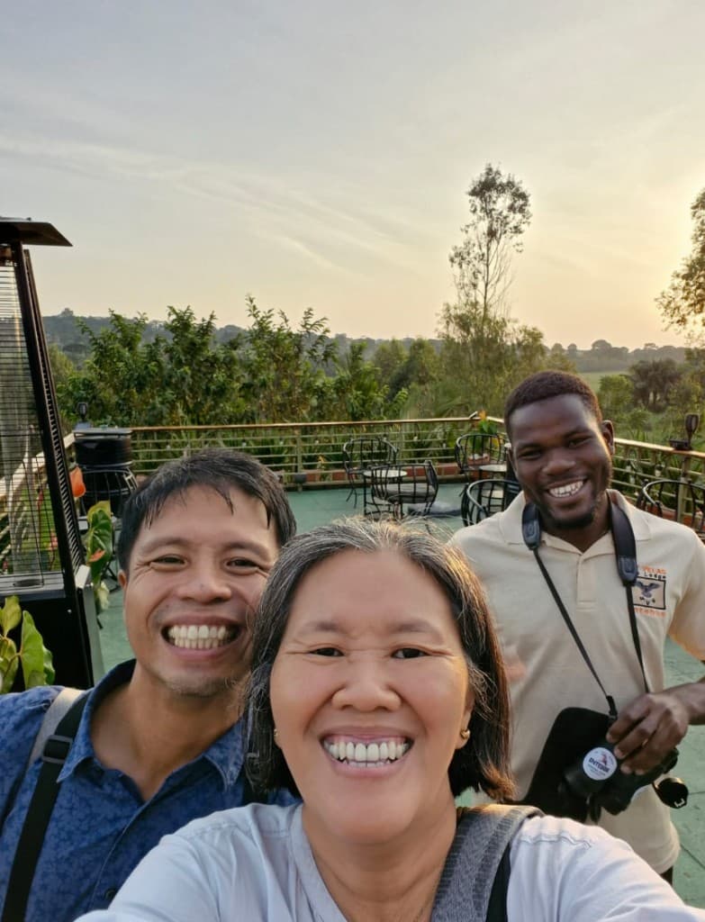 Smiling tour guide with happy travelers on an outdoor terrace at golden hour